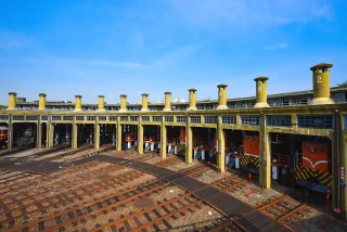 火車頭旅館 台鐵彰化機務段動力車庫興建於大正11年(西元1922年)，軌道由車庫外展如一面扇子，又稱扇形車庫，火車頭經長距離奔馳後進入車庫休息、保養，因此扇形車庫也又有「火車頭旅館」之稱。