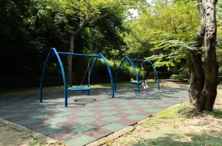 園區內設有兒童遊戲設施與休憩座椅，假日常可見親子同遊、孩童嬉戲的溫馨畫面
